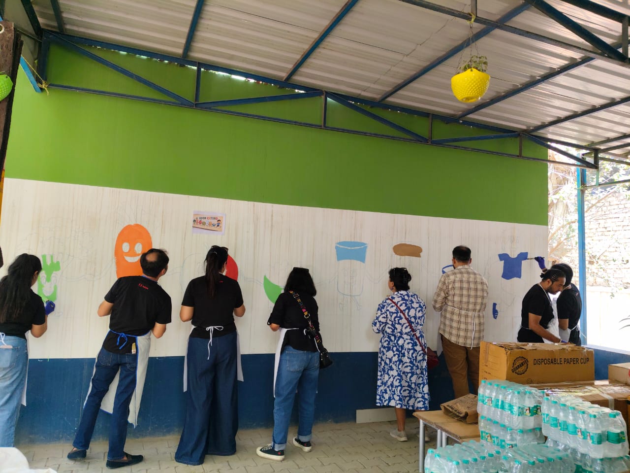Volunteers with painted wall artwork