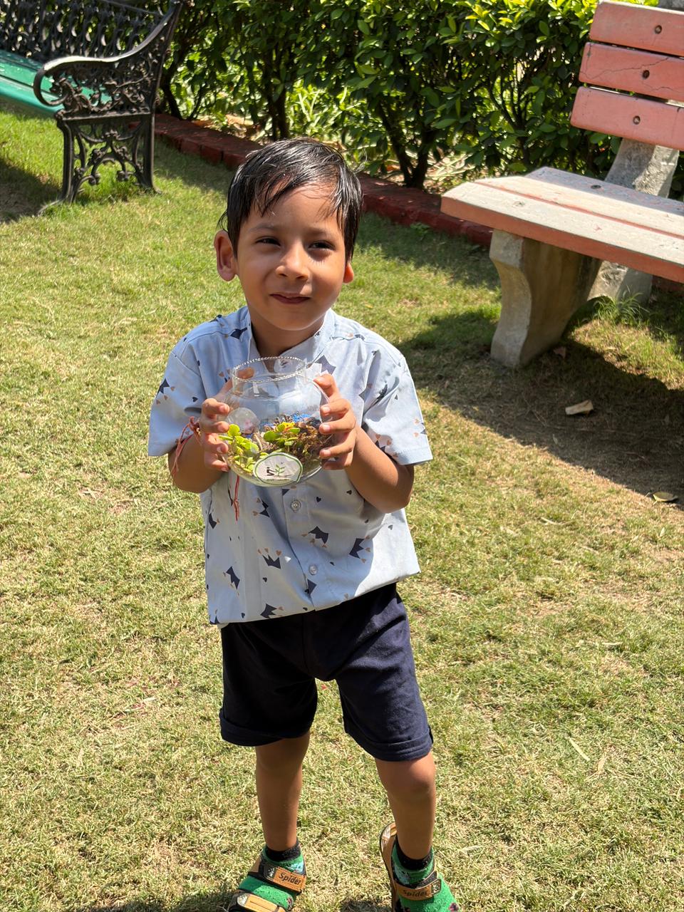 Young participant smiling while carrying a finished terrarium